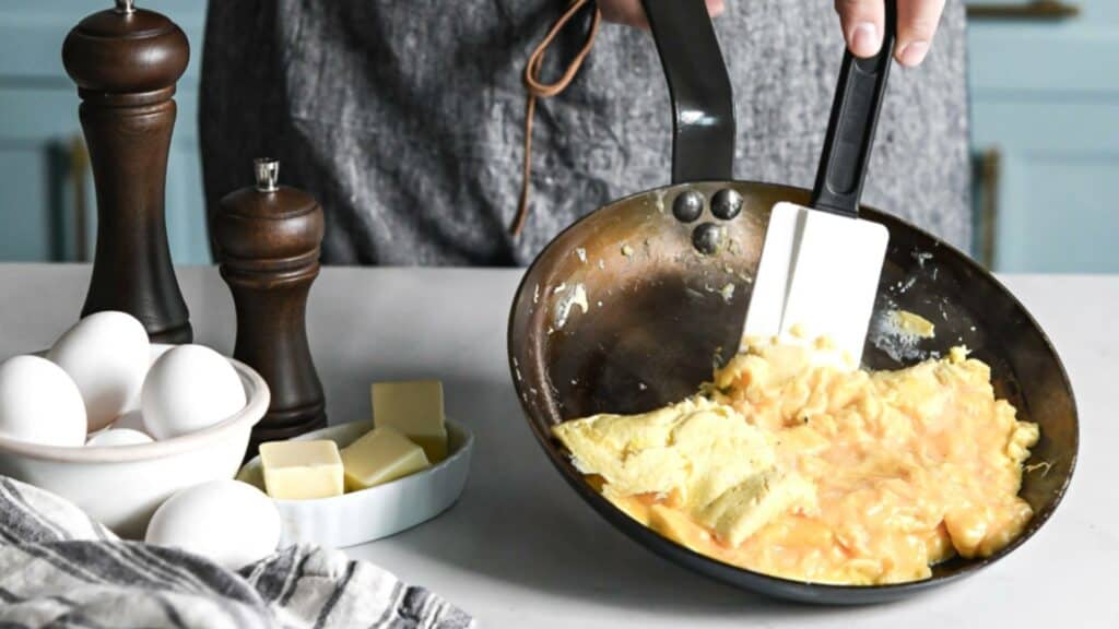 folding omelette in carbon steel pan with a spatula