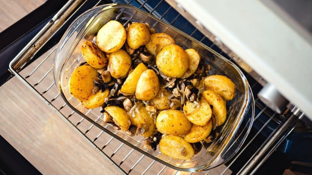 potatoes and mushrooms in glass dish go in the oven